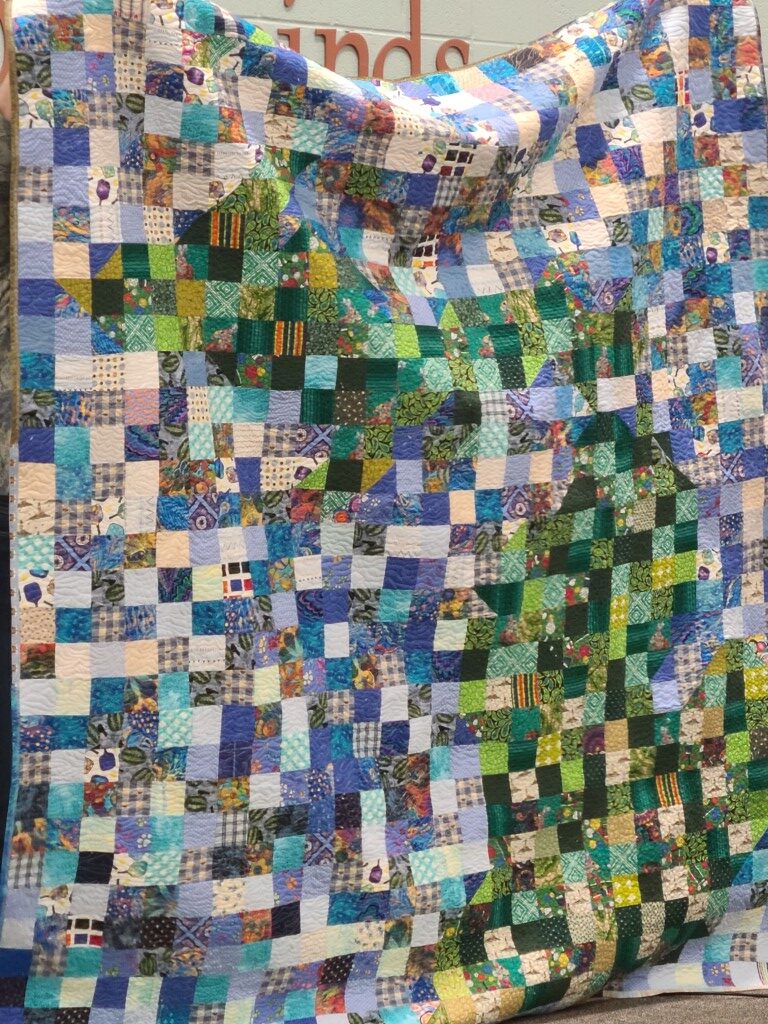 Colorful patchwork quilt with blue and green.